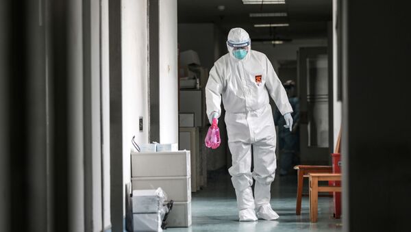 A medical worker in protective suit disinfects the hallway at Jinyintan hospital in Wuhan - Sputnik International