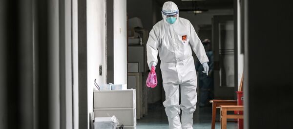 A medical worker in protective suit disinfects the hallway at Jinyintan hospital in Wuhan - Sputnik International