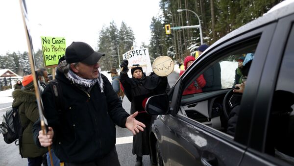 Supporters of the Wet’suwet’en nation indigenous group who oppose the construction of the Coastal GasLink pipeline, argue with a motorist during a road block protest outside the provincial headquarters of the Royal Canadian Mounted Police (RCMP) in Surrey, British Columbia, Canada January 16, 2020.  - Sputnik International