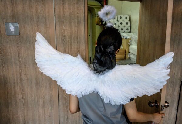 An employee of a fast-food chain wears angel wings to celebrate Valentine's Day in Bangkok on February 14, 2020.  - Sputnik International