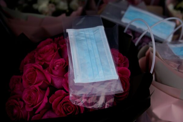 A bouquet of roses being sold with a face mask is seen at a florist on Valentine's Day, as the country is hit by an outbreak of the novel coronavirus, in Shanghai, China February 14, 2020.  - Sputnik International