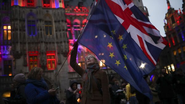 A woman holds up the Union and the European Union flags during an event called Brussels calling to celebrate the friendship between Belgium and Britain at the Grand Place in Brussels, Thursday, Jan. 30, 2020. - Sputnik International