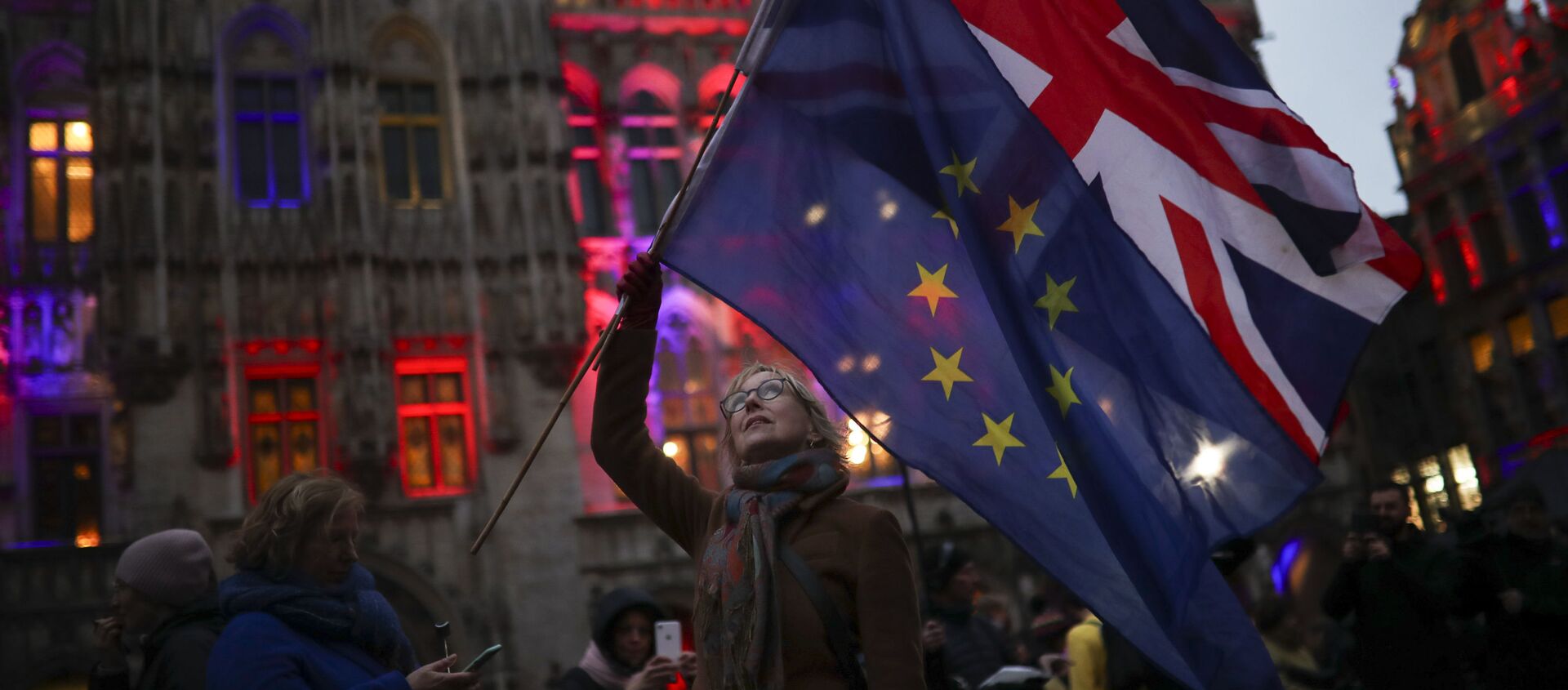 A woman holds up the Union and the European Union flags during an event called Brussels calling to celebrate the friendship between Belgium and Britain at the Grand Place in Brussels, Thursday, Jan. 30, 2020. - Sputnik International, 1920, 04.02.2021