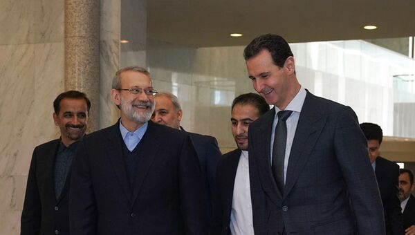 A handout picture released by the official Facebook page for the Syrian Presidency on February 16, 2020, shows Syrian President Bashar al-Assad (R) welcoming Iran's Parliament Speaker Ali Larijani in the capital Damascus - Sputnik International