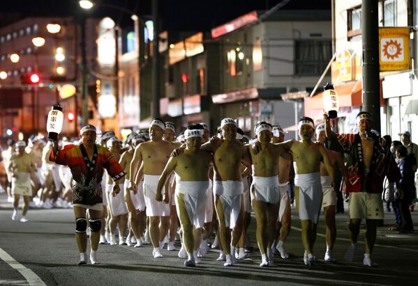 Men dressed in loincloths march as they prepare to snatch a wooden stick - Sputnik International