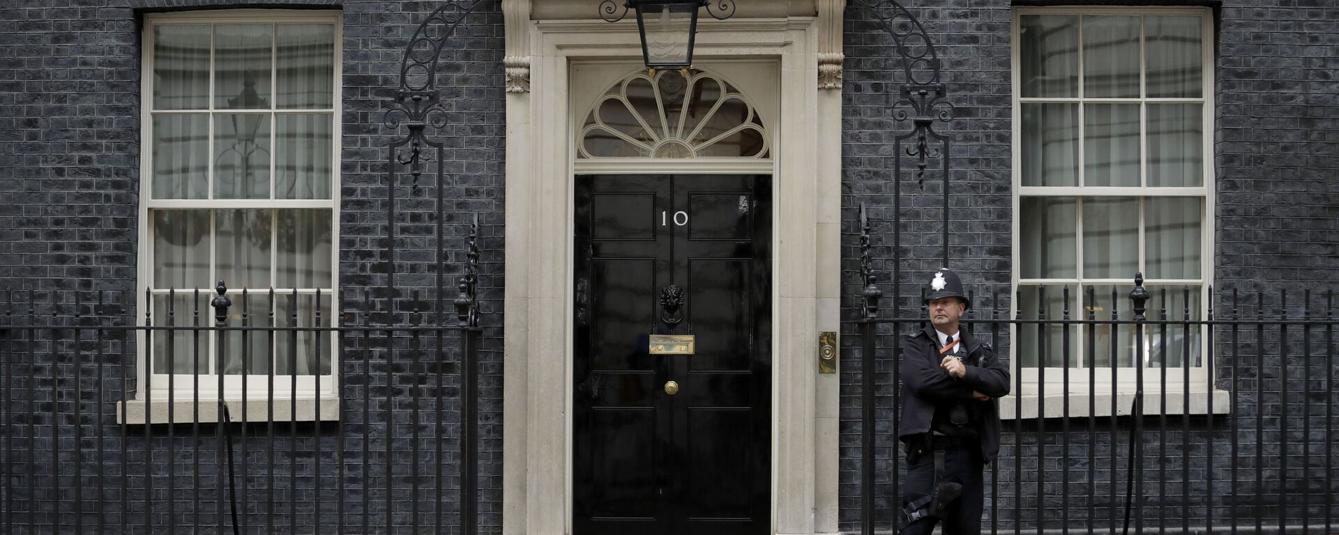 A police officer stands guard outside the door of 10 Downing Street in London, Friday, June 7, 2019 - Sputnik International, 1920, 28.05.2021