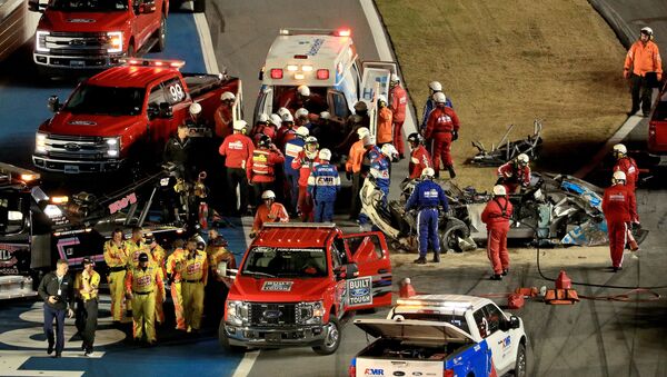 Track workers attend to Ryan Newman, driver of the #6 Koch Industries Ford, following a crash during the NASCAR Cup Series 62nd Annual Daytona 500 - Sputnik International