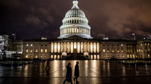 People walk along the east front plaza of the US Capitol as night falls on December 17, 2019 in Washington, DC - Sputnik International