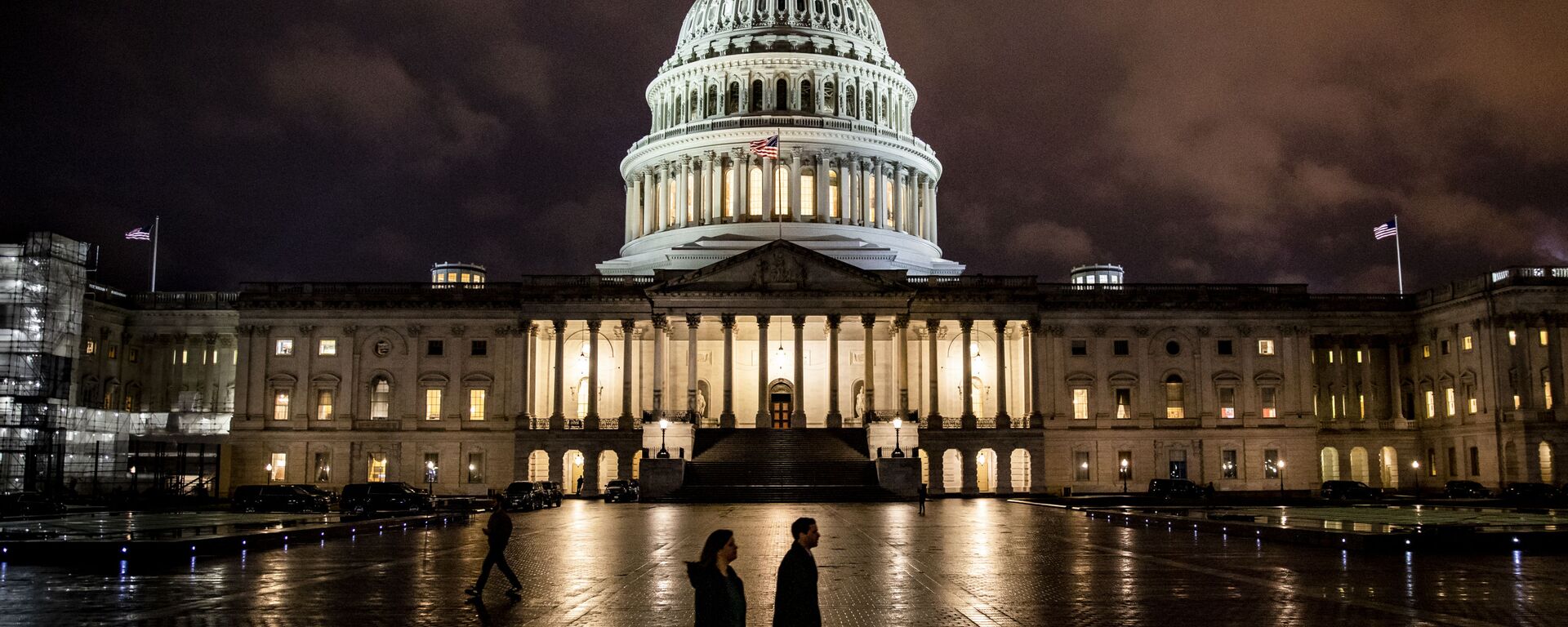 People walk along the east front plaza of the US Capitol as night falls on December 17, 2019 in Washington, DC - Sputnik International, 1920, 30.09.2021