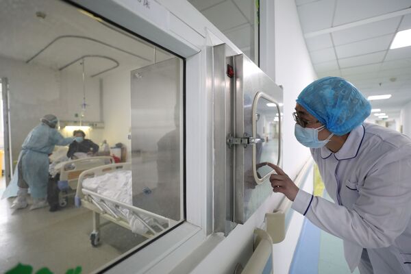 A medical worker calls his colleague inside an isolated ward at Jinyintan Hospital in Wuhan, the epicentre of the novel coronavirus outbreak, in Hubei province, China February 13, 2020. - Sputnik International