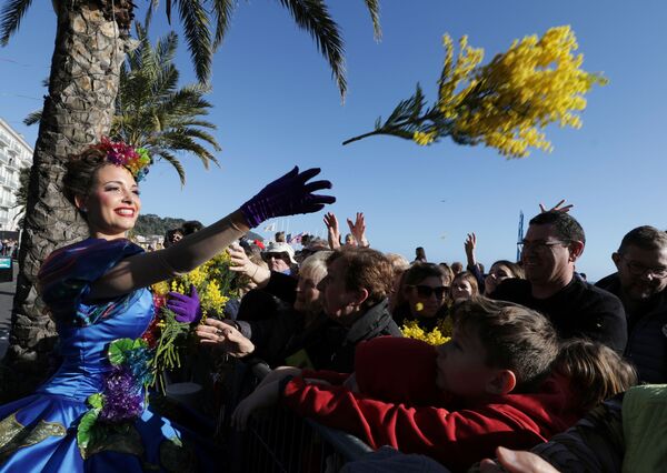 An artist throws flowers to people during the flower parade as part of the 136th Carnival parade in Nice, France, February 15, 2020.  - Sputnik International