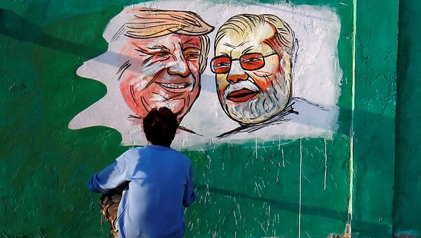 A man applies finishing touches to paintings of US President Donald Trump and India's Prime Minister Narendra Modi on a wall as part of a beautification project along a route that Trump and Modi will be taking during Trump's upcoming visit, in Ahmedabad, India, 17 February 2020. - Sputnik International