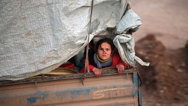 A displaced Syrian girl rides in the back of a truck on the way to Deir al-Ballut camp in Afrin's countryside along the border with Turkey, on February 19, 2020 - Sputnik International