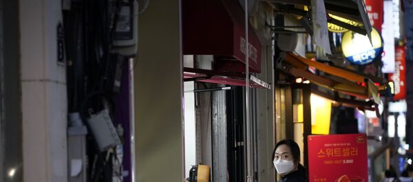 A woman wearing a mask to prevent contracting the coronavirus waits for her food at Dongseong-ro shopping street in central Daegu, South Korea February 21, 2020 - Sputnik International