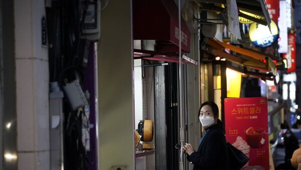 A woman wearing a mask to prevent contracting the coronavirus waits for her food at Dongseong-ro shopping street in central Daegu, South Korea February 21, 2020 - Sputnik International