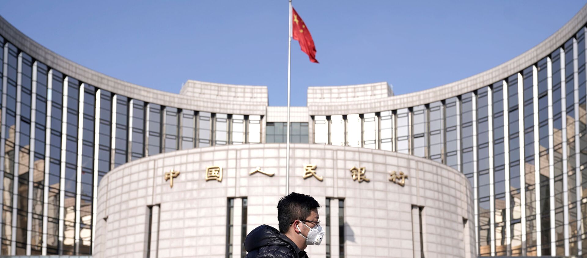 A man wearing a mask walks past the headquarters of the People's Bank of China, the central bank, in Beijing, China, as the country is hit by an outbreak of the new coronavirus, February 3, 2020 - Sputnik International, 1920, 09.10.2020