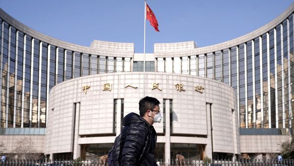 A man wearing a mask walks past the headquarters of the People's Bank of China, the central bank, in Beijing, China, as the country is hit by an outbreak of the new coronavirus, February 3, 2020 - Sputnik International