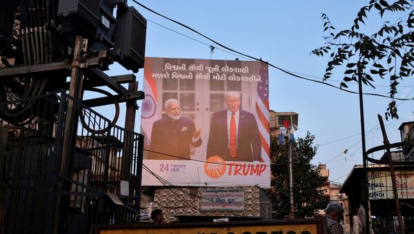 A man stands next to a hoarding with the images of U.S. President Donald Trump and India's Prime Minister Narendra Modi, ahead of Trump's visit, in Ahmedabad, India, February 23, 2020. - Sputnik International