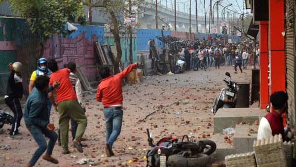 People supporting a new citizenship law and those opposing the law, throw stones at each other during a clash in Maujpur area of New Delhi, India, February 23, 2020. - Sputnik International