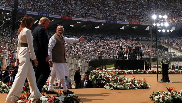 Donald Trump is led to the podium in Ahmedabad by Prime Minister Narendra Modi  - Sputnik International