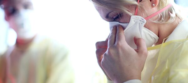 A member of the Red Cross attaches a respirator mask during a demonstration at the Vienna International Airport in Schwechat, Austria, February 6, 2020 - Sputnik International
