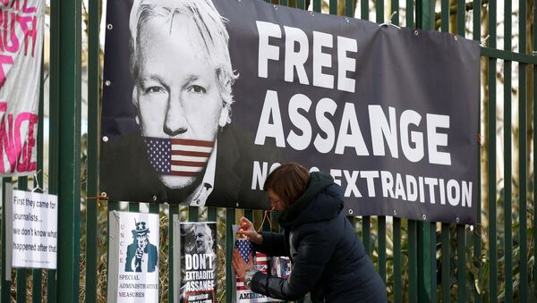 A supporter of WikiLeaks founder Julian Assange posts a sign on the Woolwich Crown Court fence, ahead of a hearing to decide whether Assange should be extradited to the United States, in London, Britain February 25, 2020. - Sputnik International
