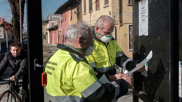 Life inside a red zone: Lombardy civil protection officers wearing protective masks put up posters in San Fiorano, one of the towns on lockdown due to a coronavirus outbreak, in this picture taken by schoolteacher Marzio Toniolo in San Fiorano, Italy, 24 February 2020. - Sputnik International