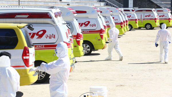 Medical workers get ready as ambulances are parked to transport a confirmed coronavirus patient in Daegu, South Korea, February 23, 2020 - Sputnik International