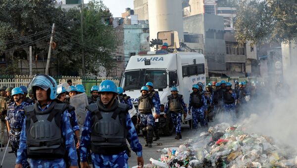 Members of Rapid Action Force (RAF) move past smoldering debris after it was set on fire by demonstrators in a riot affected area after fresh clashes erupted between people demonstrating for and against a new citizenship law in New Delhi, India, February 25, 2020.  - Sputnik International