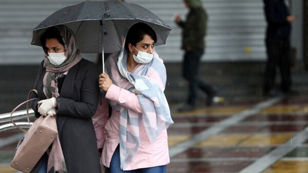 Iranian women wear protective masks to prevent contracting coronavirus, as they walk in the street in Tehran, Iran February 25, 2020.  - Sputnik International
