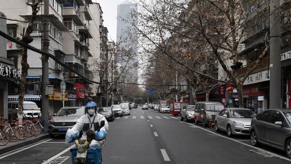 A delivery driver wearing protective gear rides past closed shops in Wuhan, the epicentre of the novel coronavirus outbreak, Hubei province, China February 27, 2020 - Sputnik International