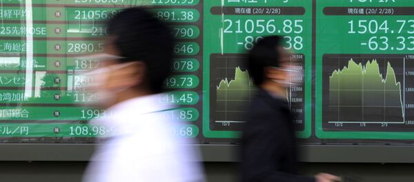 People wearing protective face masks, following an outbreak of the coronavirus, walk past a screen showing Nikkei index, outside a brokerage in Tokyo, Japan February 28, 2020. - Sputnik International
