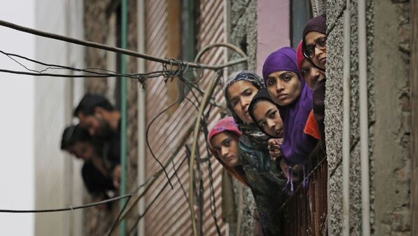 Indian Muslim women look out of a window as security officers patrol a street in New Delhi - Sputnik International