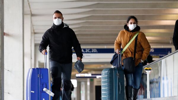 People wearing protective face masks walk as they arrive at Charles de Gaulle airport near Paris, France, as the coronavirus outbreak continues to expand, February 29, 2020. - Sputnik International