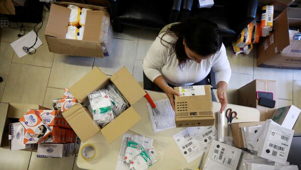 An employee packs medical masks, that are part of personal protection and survival equipment kits ordered by customers preparing against novel coronavirus, at a centre of an express delivery company in Porto Alegre, Brazil February 28, 2020. REUTERS/Diego Vara - Sputnik International