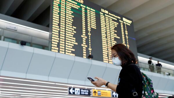 FILE PHOTO: A passenger in a protective mask uses her phone at Rome's Fiumicino airport, after first cases of coronavirus were confirmed in Italy, January 31, 2020. REUTERS/Yara Nardi/File Photo - Sputnik International