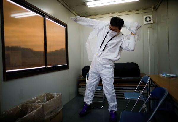 Yuji Onuma, an evacuee from Futaba Town near tsunami-crippled Fukushima Daiichi nuclear power plant, wears a protective suit as he prepares for entering to the exclusion zone around the plant, in Namie Town, Fukushima Prefecture, Japan February 20, 2020 - Sputnik International
