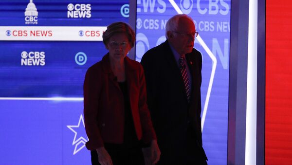 Democratic presidential candidates, Sen. Elizabeth Warren, D-Mass., left, and Sen. Bernie Sanders, I-Vt., right, walks off the stage during a commercial break as they participate in a Democratic presidential primary debate at the Gaillard Center, Tuesday, Feb. 25, 2020, in Charleston, S.C., co-hosted by CBS News and the Congressional Black Caucus Institute. - Sputnik International