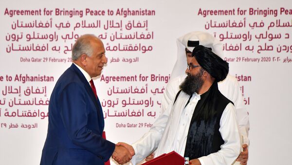 US Special Representative for Afghanistan Reconciliation Zalmay Khalilzad and Taliban co-founder Mullah Abdul Ghani Baradar shake hands after signing a peace agreement during a ceremony in the Qatari capital Doha on February 29, 2020 - Sputnik International