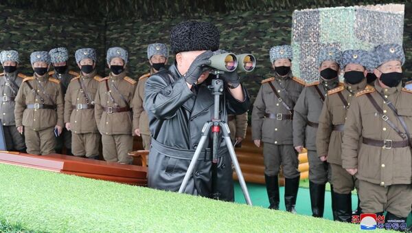 North Korean leader Kim Jong-un looks into binoculars during a missile test. - Sputnik International