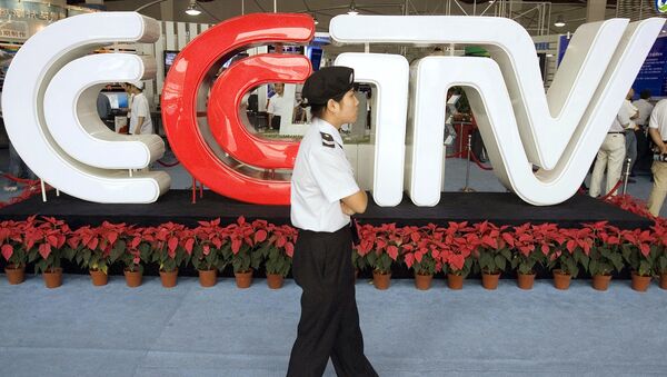 Chinese security personnel walks past the logo for China Central Television (File) - Sputnik International