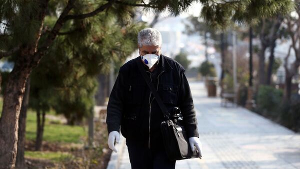 An Iranian man wears a protective mask against the coronavirus as he walks on a street in Tehran, Iran February 29, 2020 - Sputnik International