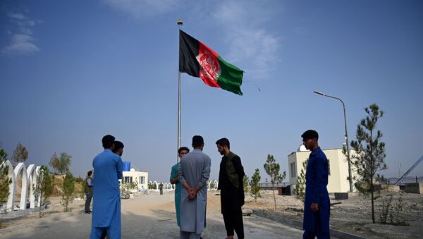 Afghanistan's national flag flutters as youths stand at Wazir Akbar Khan hilltop overlooking Kabul on September 29, 2019 - Sputnik International