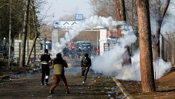 A migrant runs away from tear gas at Turkey's Pazarkule border crossing with Greece's Kastanies, near Edirne, Turkey, March 2, 2020 - Sputnik International