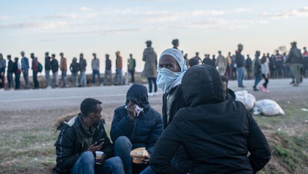 Migrants wait for a food distribution in front of the Pazarkule border crossing to Greece, on March 3, 2020, at Pzarkule in Edirne. - Sputnik International