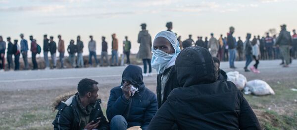 Migrants wait for a food distribution in front of the Pazarkule border crossing to Greece, on March 3, 2020, at Pzarkule in Edirne. - Sputnik International