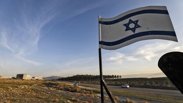An Israeli flag hovers cars driving by the Israeli settlement of Shlomtzion in the Jordan valley in the occupied West Bank on January 27, 2020. - Sputnik International