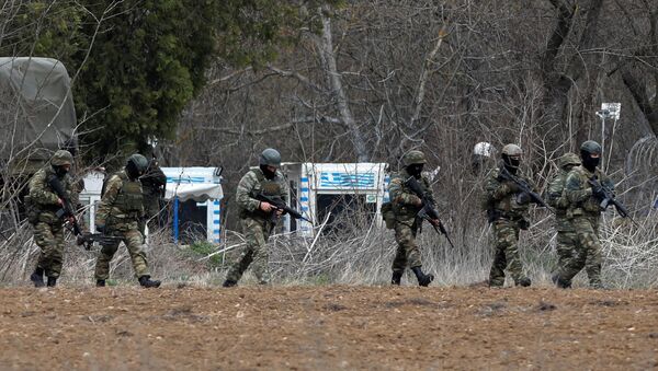Soldiers holding guns walk near Turkey's Pazarkule border crossing, in Kastanies, Greece March 4, 2020 - Sputnik International