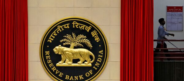 FILE PHOTO: A worker walks past the logo of Reserve Bank of India inside its office in New Delhi - Sputnik International