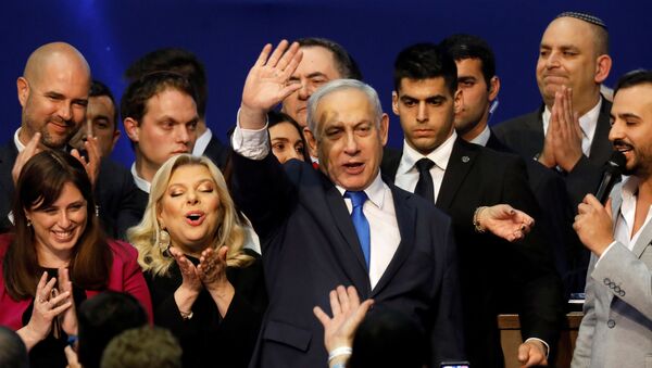 Israeli Prime Minister Benjamin Netanyahu stands next to his wife Sara as he waves to supporters following the announcement of exit polls in Israel's election at his Likud party headquarters in Tel Aviv, Israel March 3, 2020 - Sputnik International